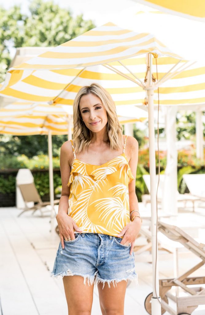 Those Hot Summer Nights... A New Collection from Gibson! by popular Nashville fashion blog Hello Happiness: image of a woman standing outside and wearing a white and gold palm Gibson Hot Summer Nights Two Peas Ruffle Detail Satin Camisole.