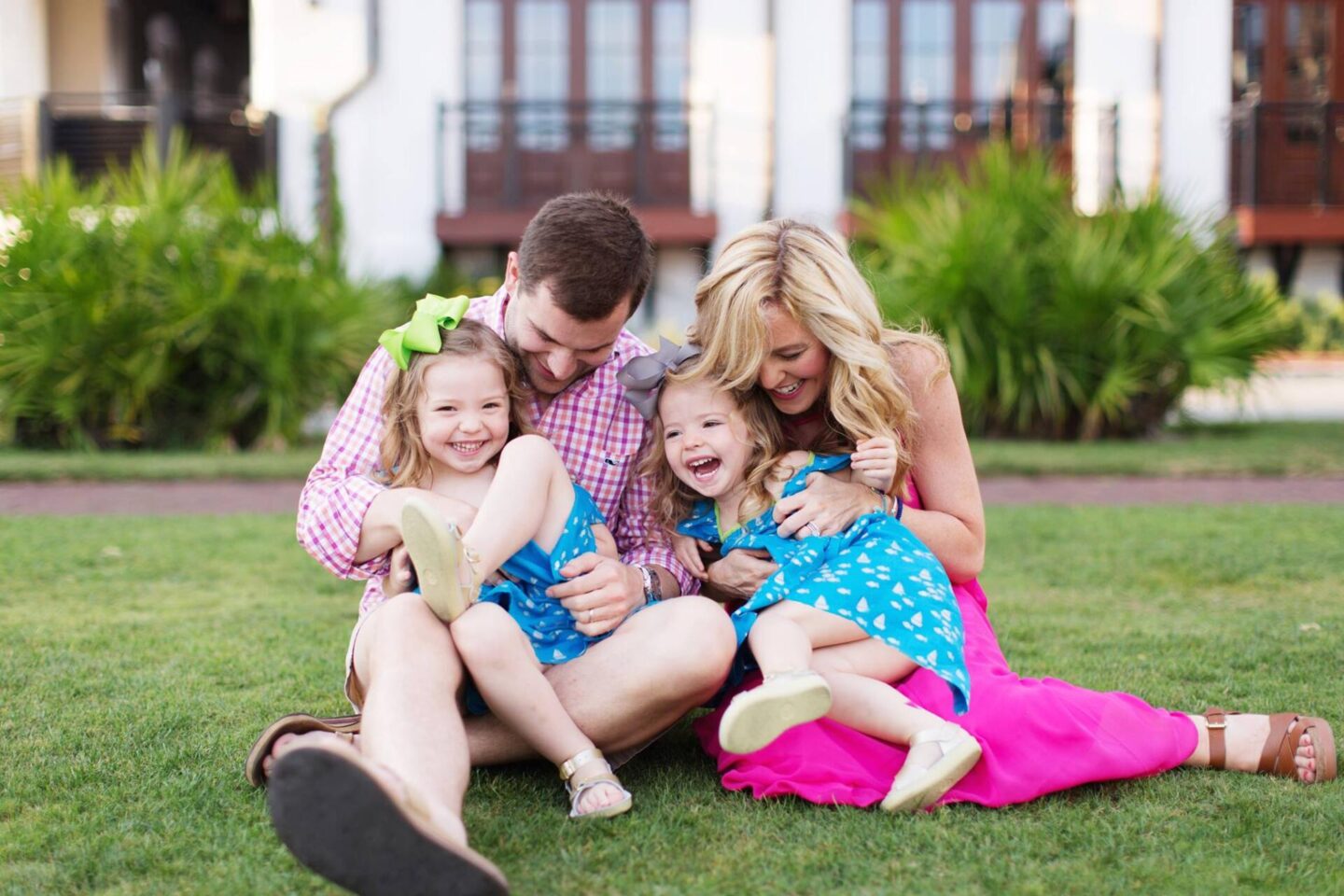 10 Year Wedding Anniversary by popular Nashville lifestyle blog, Hello Happiness: image of a mom and dad sitting on the grass with their two young daughters. 