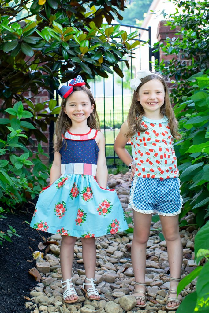 Ready, Set, SHOP! The Best in 4th of July Sales by popular Nashville fashion blog, Hello Happiness: image of two young girls wearing Matilda Jane Clothing Popsicle Stand Tank, Matilda Jane Clothing Pick Up Game Short, and Matilda Jane Clothing On Parade Dress.