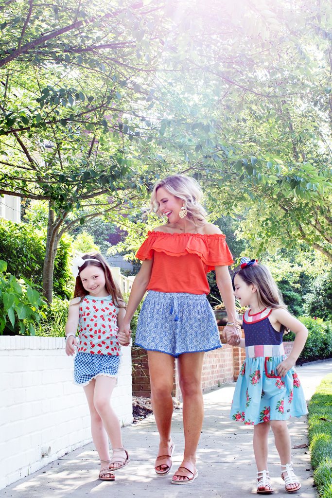 Ready, Set, SHOP! The Best in 4th of July Sales by popular Nashville fashion blog, Hello Happiness: image of mom and two daughters holding hands and walking outside and wearing Matilda Jane Clothing Cool Breeze Short and Matilda Jane Clothing Everything I See Top.