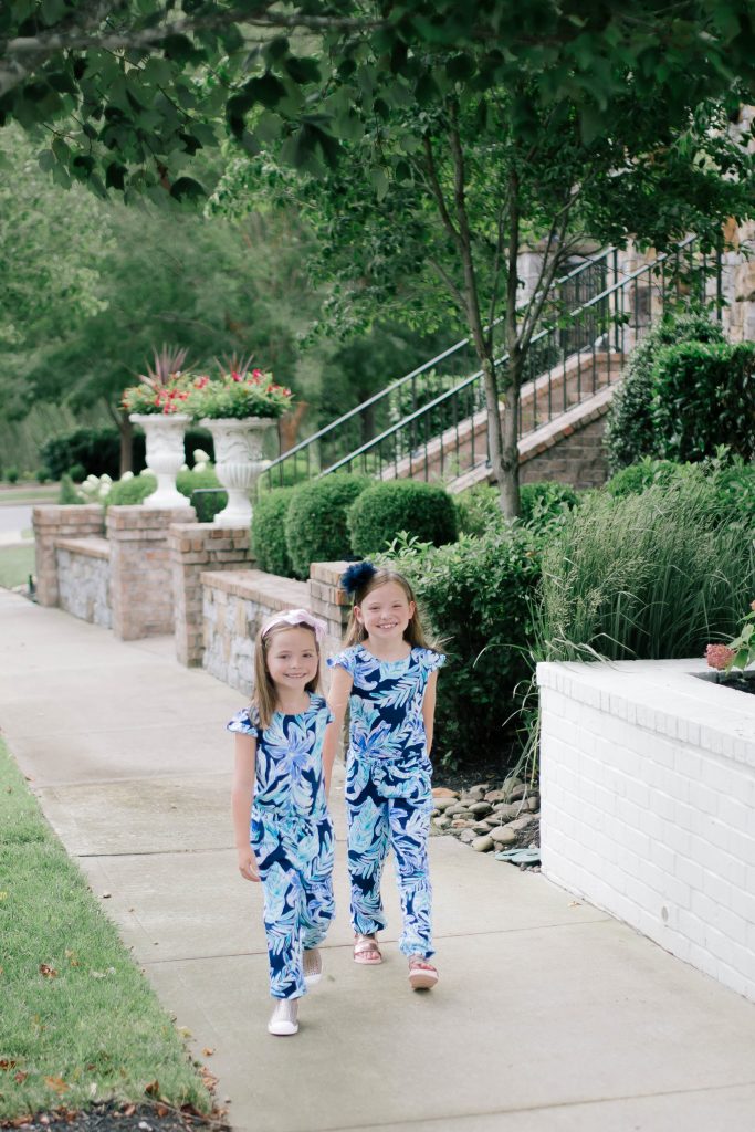 Raising Worry Free Girls by Sissy Goff by popular Nashville life and style blog, Hello Happiness: image of two girls outside wearing Nordstrom Native Shoes Jefferson Bling Glitter Slip-On Vegan Sneaker, Nordstrom Mel by Melissa Cosmic Sandal, and Lilly Pulitzer GIRLS ODESSA JUMPSUIT.