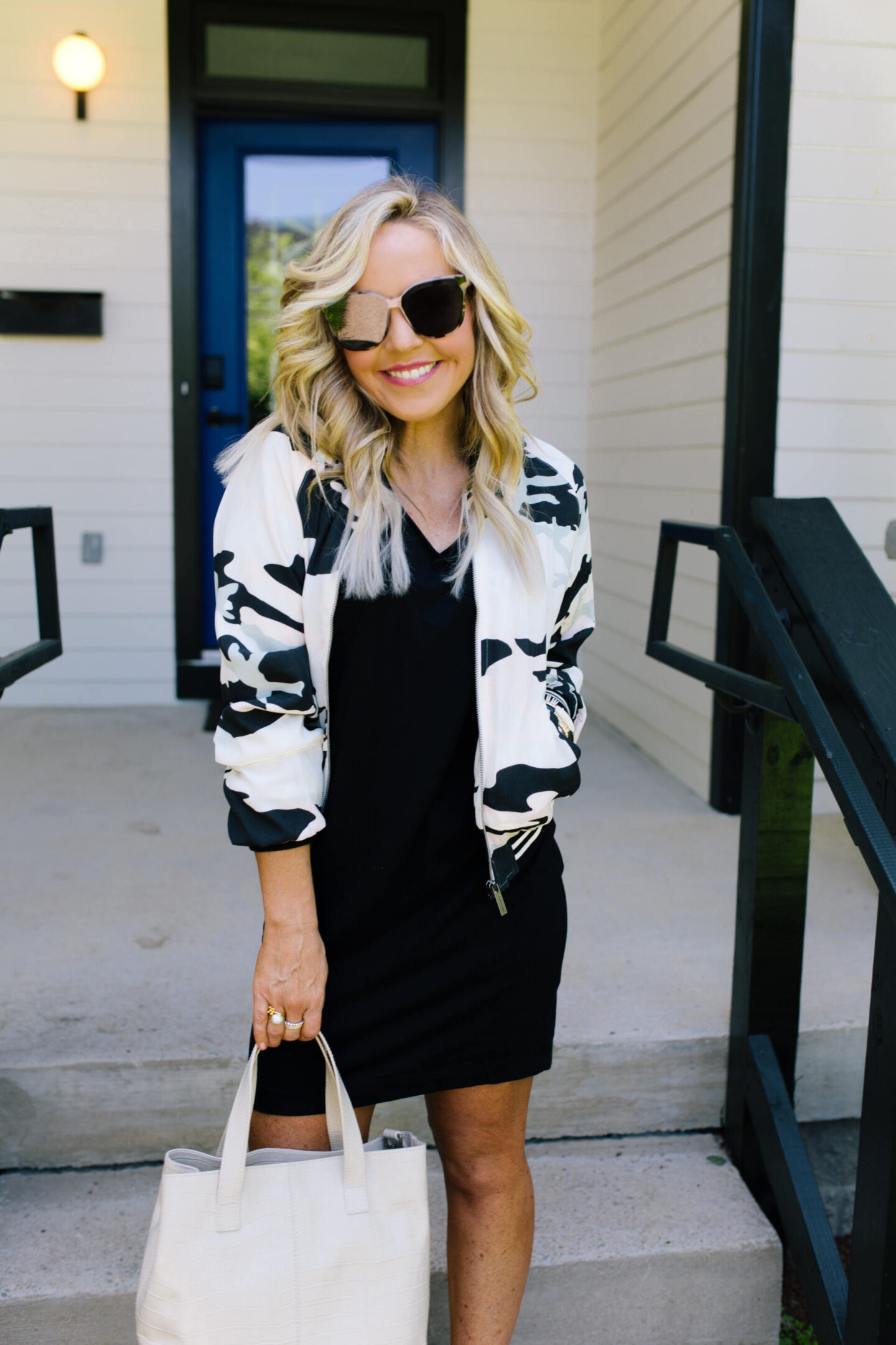 Summer Dress by popular Nashville fashion blog, Hello Happiness: image of a woman standing on some cement stairs and wearing a black and white Havana Fever Bomber, Cara Tee Dress, and Kortlen Studded Slide. 