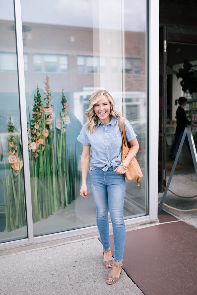 ABLE featured by top US fashion blog Hello! Happiness; Image of a woman wearing a button-up shirt, skinny jeans, earrings and purse from ABLE