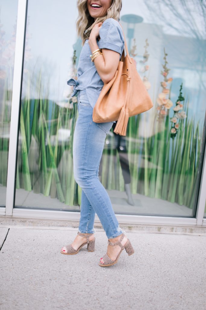 ABLE featured by top US fashion blog Hello! Happiness; Image of a woman wearing a button-up shirt, skinny jeans, earrings and purse from ABLE