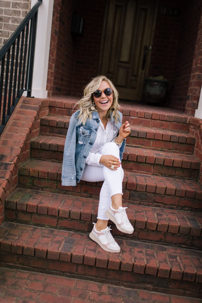 Ready, Set, SHOP! The Best in 4th of July Sales by popular Nashville fashion blog, Hello Happiness: image of woman sitting on a brick staircase and wearing a denim jacket, a white button up top, white jeans and Marc Fisher LTD Janette Espadrille Sneakers.