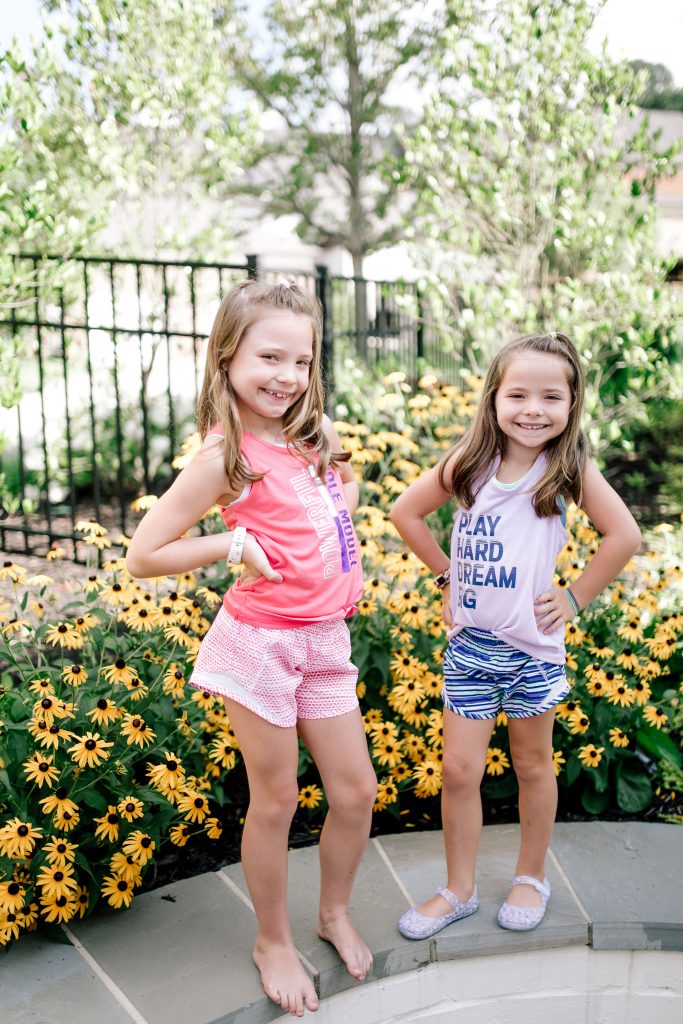Trend Setting Back-to-School Outfits from Walmart by popular Nashville fashion blog, Hello Happiness: image of two girls standing outside wearing Walmart Athletic Works Graphic Active Tank Racer Back and Athletic Works Active Running Shorts.