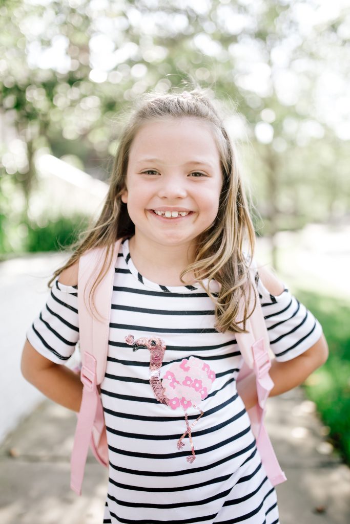 Walmart Back to School Style for 2nd Grade! by popular Nashville fashion blog, Hello Happiness: image of a girl standing outside and wearing a Walmart Sequin Flamingo Bow Back Dress