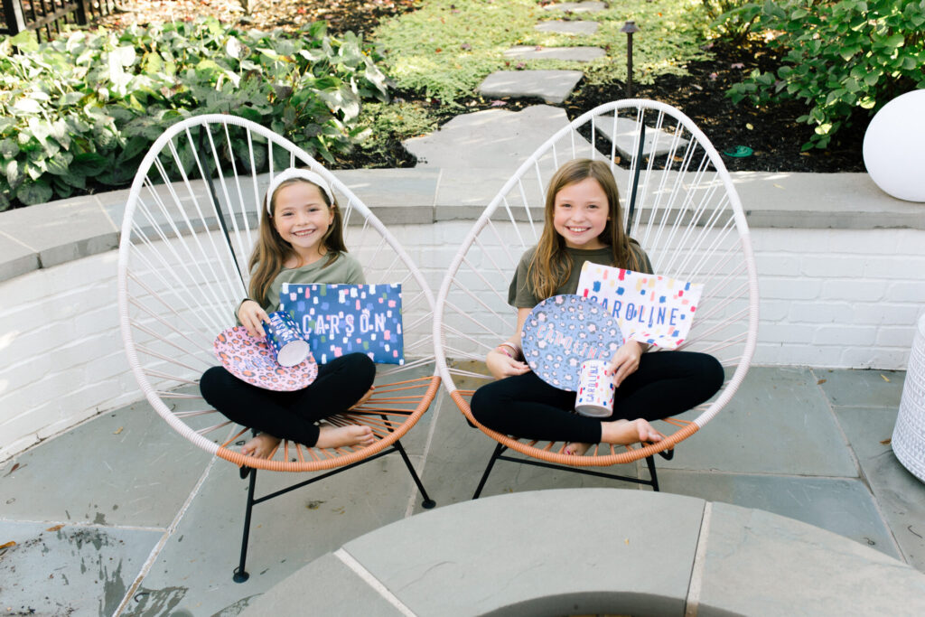 Support Local Business by popular Nashville life and style blog, Hello Happiness: image of two girls sitting outside and holding Clairebella personalized items. 