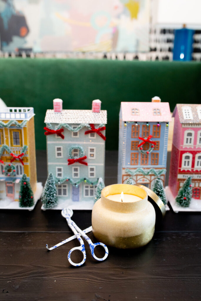 Holiday Gift Ideas by popular Nashville life and style blog, Hello Happiness: image of a colorful Christmas village and gold glitter candle. 