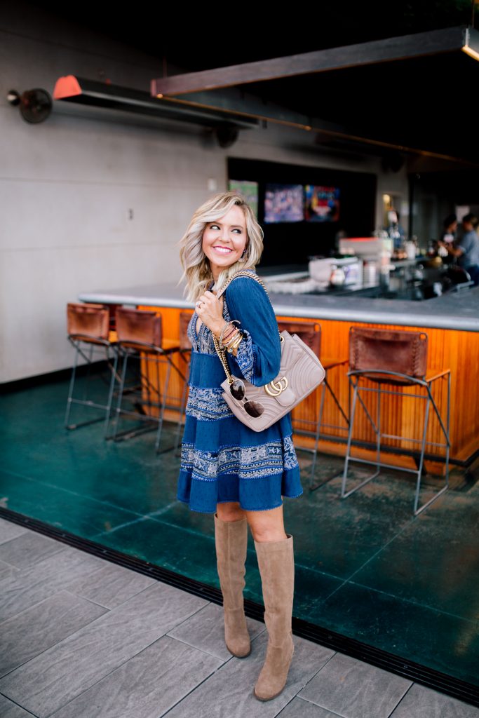 The New and Now at Noelle Nashville by popular Nashville blog, Hello Happiness: image of a woman at the Rarebird Rooftop Bar in the Noelle hotel in Nashville and wearing a Free People My Love Long Sleeve Minidress, Sole Society PRONY WEDGE BOOT, Nordstrom Gucci Medium GG Marmont 2.0 Matelassé Leather Shoulder Bag, and Able earrings. 
