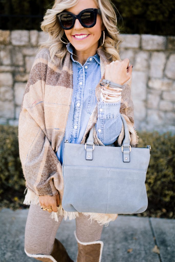 2019 Holiday Gift Guide | 2019 Holiday Gift Guide | Best Cyber Week Sales and Deals by popular Nashville life and style blog, Hello Happiness: image of a woman standing outside and wearing a denim button up shirt, striped cardigan and holding a grey purse.