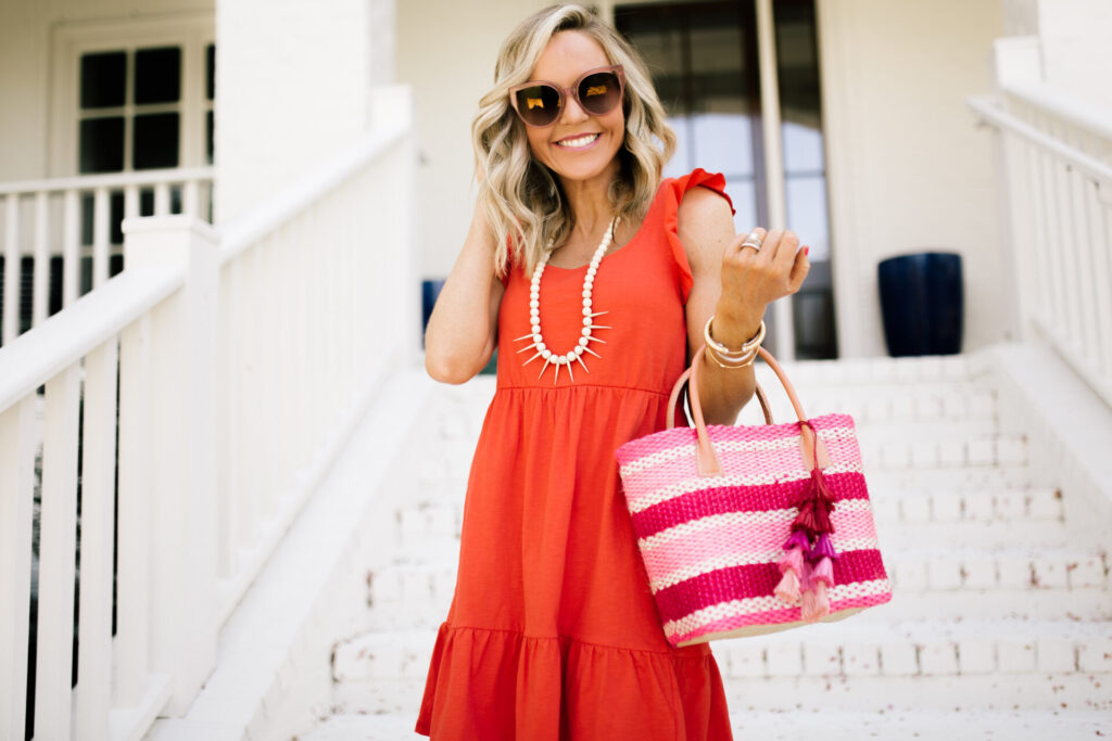 Personal Questions by popular Nashville lifestyle blog, Hello Happiness: image of Natasha Stoneking wearing a red dress, sunglasses, and holding a pink and white stripe bag. 
