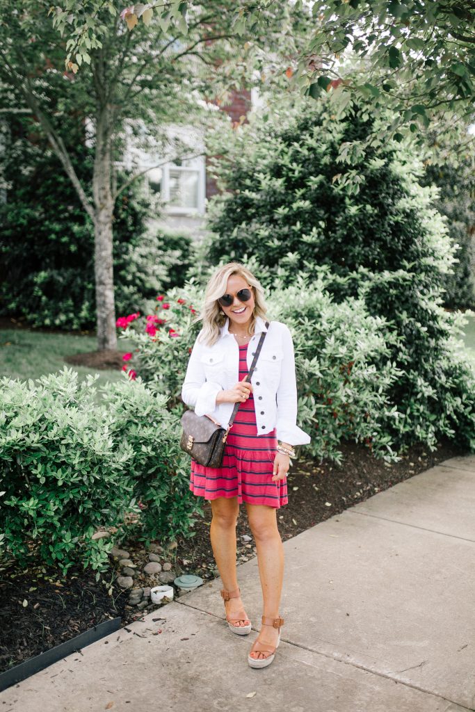 My Favorite Summer Ensembles... One and Done Wonders by popular Nashville fashion blog, Hello Happiness: image of a woman outside wearing a Striped Verona Dress, white denim jacket, Audrina Sandals, Cosmo Sunglasses, and Metis Pochette Crossbody. 