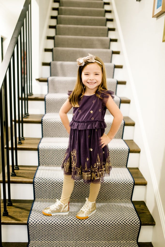 Party-Worthy Looks with the Boden Harry Potter Collection by popular Nashville fashion blog, Hello Happiness: image of a girl standing on some stairs and wearing a Boden Hogwarts Enchanted Tulle Dress, Boden High Tops, and Boden sparkly tights. 