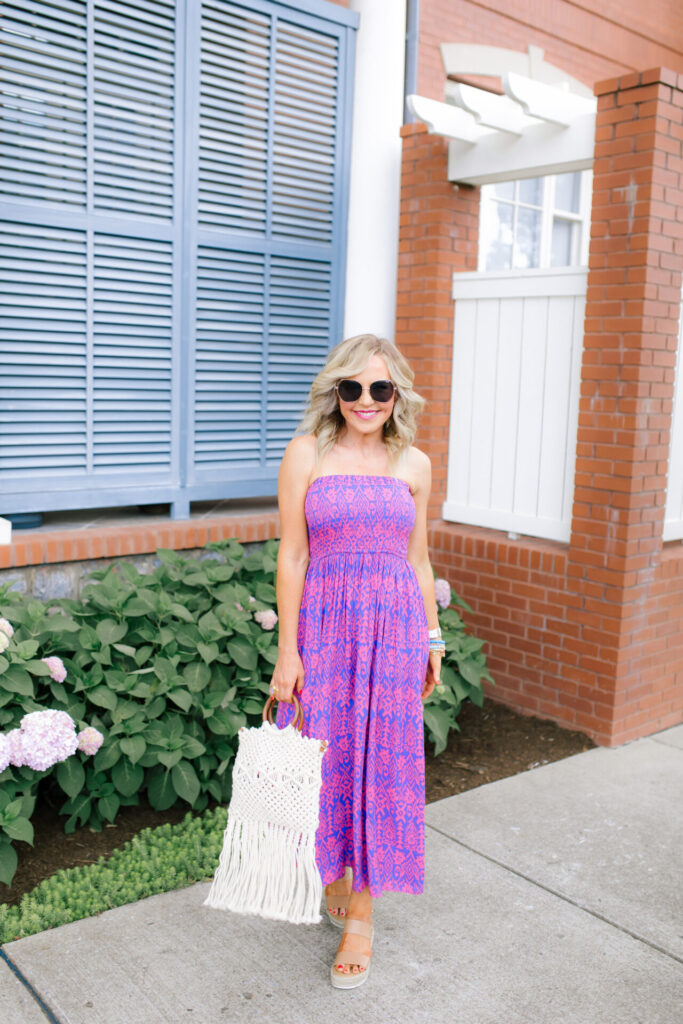 Walmart Scoop by popular Nashville fashion blog, Hello Happiness: image of a woman standing outside and wearing a Walmart Scoop Women’s Smock Top Strapless Printed Maxi Dress, Walmart Quay Women's Gradient Breeze In QW-000378-GLD/BRN Gold Geometric Sunglasses, Walmart Scoop Macrame Wooden Handle Tote Bag, and Walmart Wodstyle Womens Platform Espadrille Sandals Buckle Peep Toe Summer Casual Shoe.