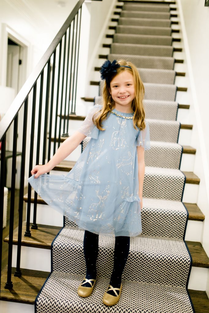 Party-Worthy Looks with the Boden Harry Potter Collection by popular Nashville fashion blog, Hello Happiness: image of a girl standing on some stairs and wearing a Boden Patronus Party Dress, Boden Party Twinkle Tights, and Boden Party Ballet Flats. 