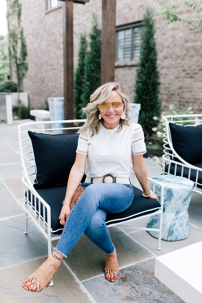 Snakeskin + Leopard...My Vince Camuto Favorites by popular Nashville blog, Hello Happiness: image of a woman sitting outside in a patio chair wearing Vince Camuto  Kresseya High-Heel Sandals and holding a Vince Camuto Iggy Tassel Clutch.