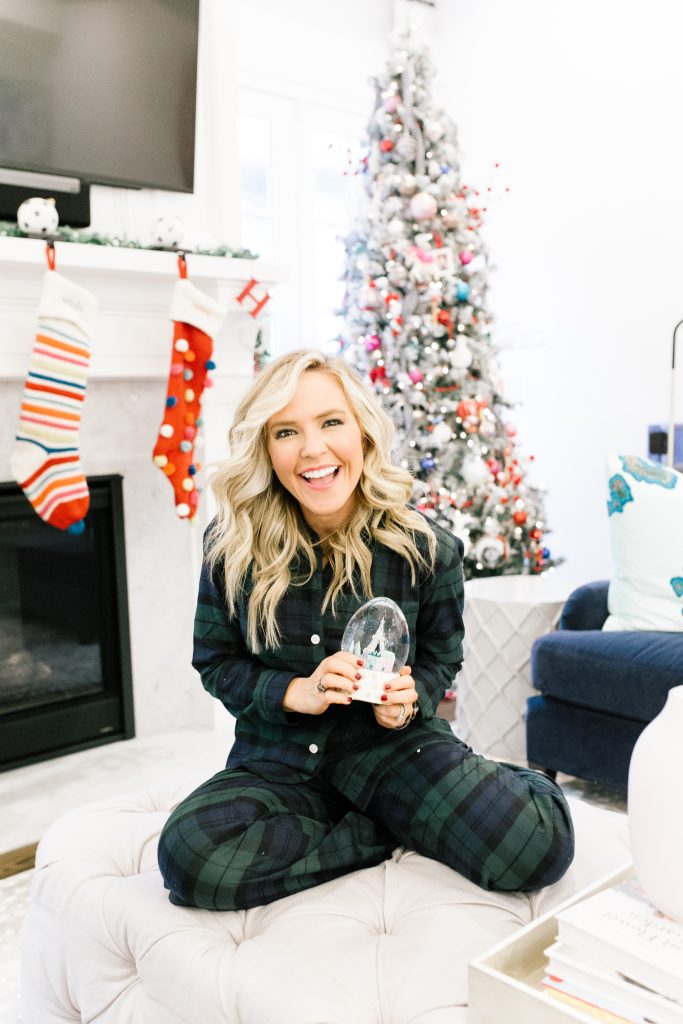 The 2019 Holiday Gift Guides... Home + Decor and All the Ornaments by popular Nashville life and style blog, Hello Happiness: image of a woman in flannel pajamas and holding a snow globe in front of a decorated Christmas tree. 