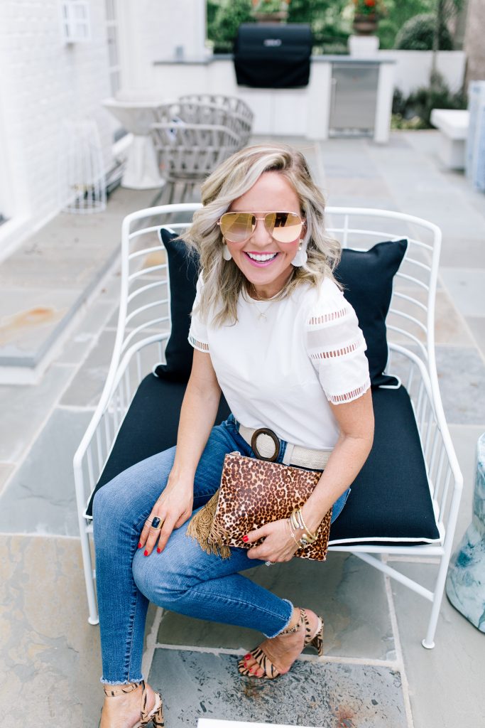 Snakeskin + Leopard...My Vince Camuto Favorites by popular Nashville blog, Hello Happiness: image of a woman sitting outside in a patio chair wearing Vince Camuto  Kresseya High-Heel Sandals and holding a Vince Camuto Iggy Tassel Clutch.