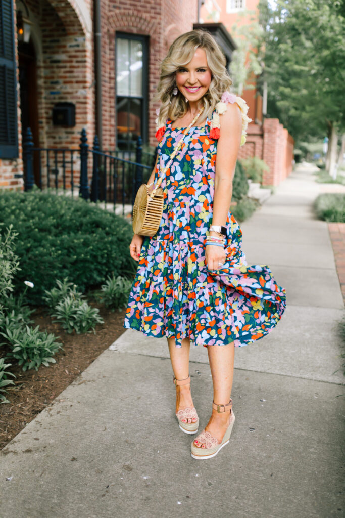Personal Questions by popular Nashville lifestyle blog, Hello Happiness: image of Natasha Stoneking standing outside and wearing a J.Crew Tassel dress in confetti floral, ShopBop See by Chloe Glyn Wedge Espadrilles, Amazon Deerludie & T Women Bamboo Purse Handbag, and MLDED clay earrings. 