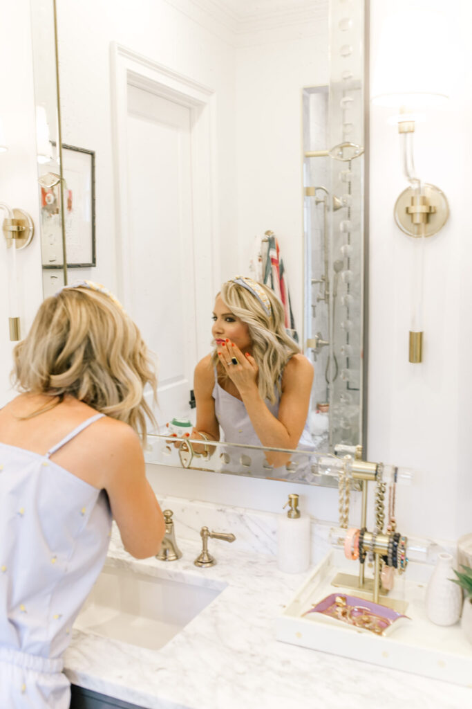 Personal Questions by popular Nashville lifestyle blog, Hello Happiness: image of Natasha Stoneking applying a skin care product in her bathroom. 