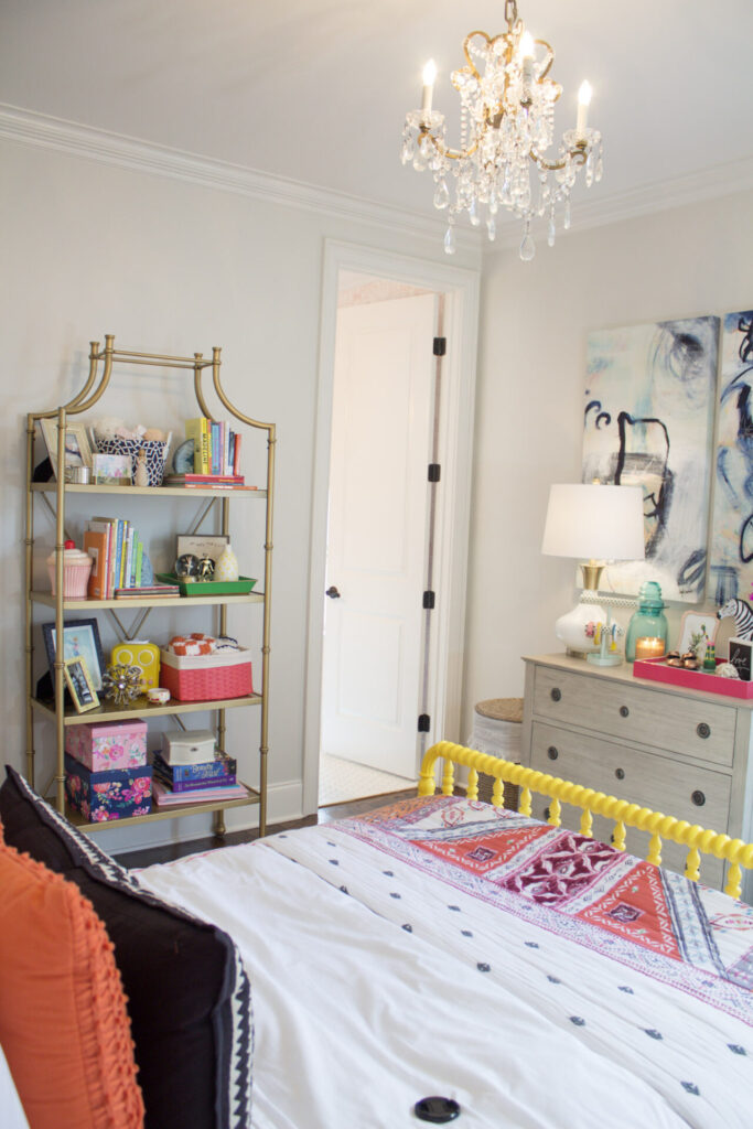 Home Paint Colors by popular Nashville life and style blog, Hello Happiness: image of a little girl's room with a crystal chandelier, yellow jenny lind bed and walls painted with Sherwin Williams First Star. 