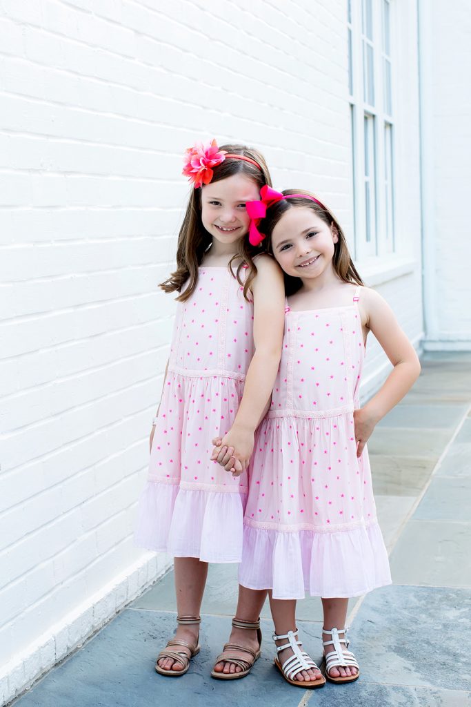 Ready, Set, SHOP! The Best in 4th of July Sales by popular Nashville fashion blog, Hello Happiness: image of two young girls standing outside in front of white brick building wearing Boden Woven Pink Polka Dot Maxis.