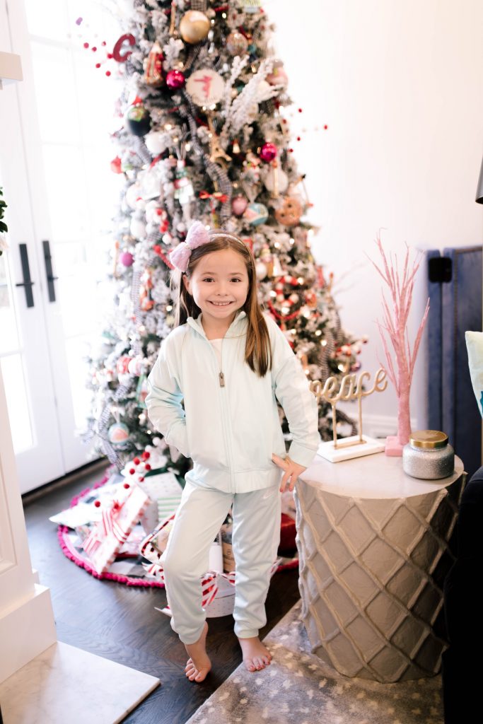 Everything Holiday with Academy Sports + Outdoors Gifts by popular life and style blog, Hello Happiness: image of a girl wearing a Academy Sports + Outdoors Nike track suit.