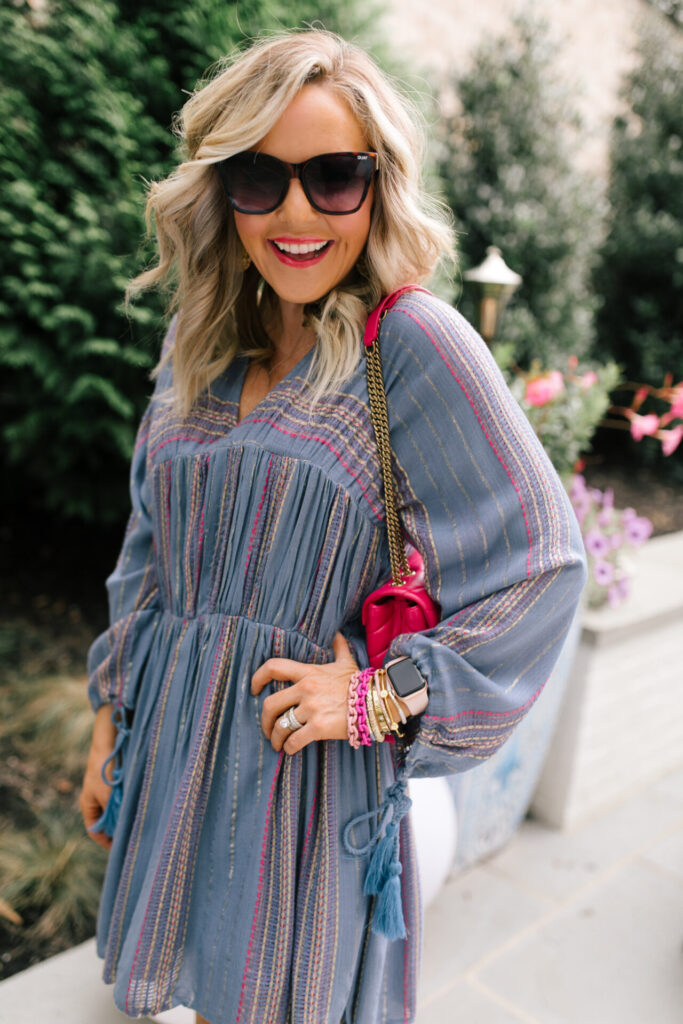 Under $100 by popular Nashville fashion blog, Hello Happiness: image of Natasha Stoneking wearing a Asos Metallic tiered smock dress, tan ankle boots, and holding a pink YSL purse. 