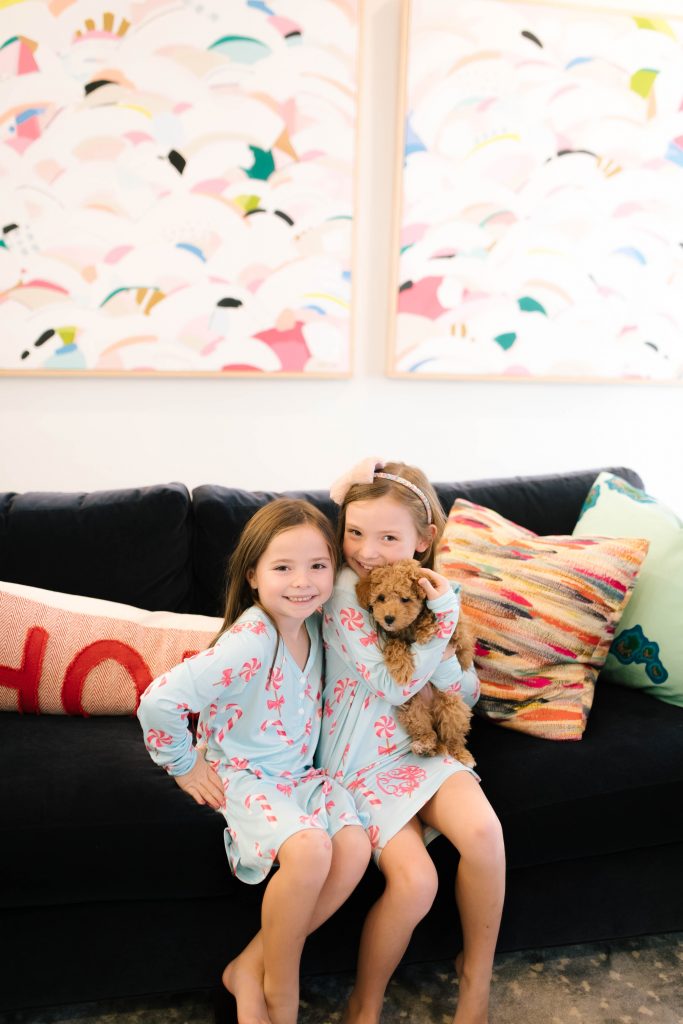 Life with Tucker + The Best Pet Gifts by popular life and style blog, Hello Happiness: image of two girls holding a goldendoodle puppy and wearing I Love JewelryMONOGRAM CANDY LAND NIGHTGOWNS.