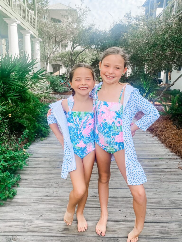 Rosemary Beach by popular Nashville travel blog, Hello Happiness: image of two girls wearing matching swimsuits and standing together on a boardwalk. 