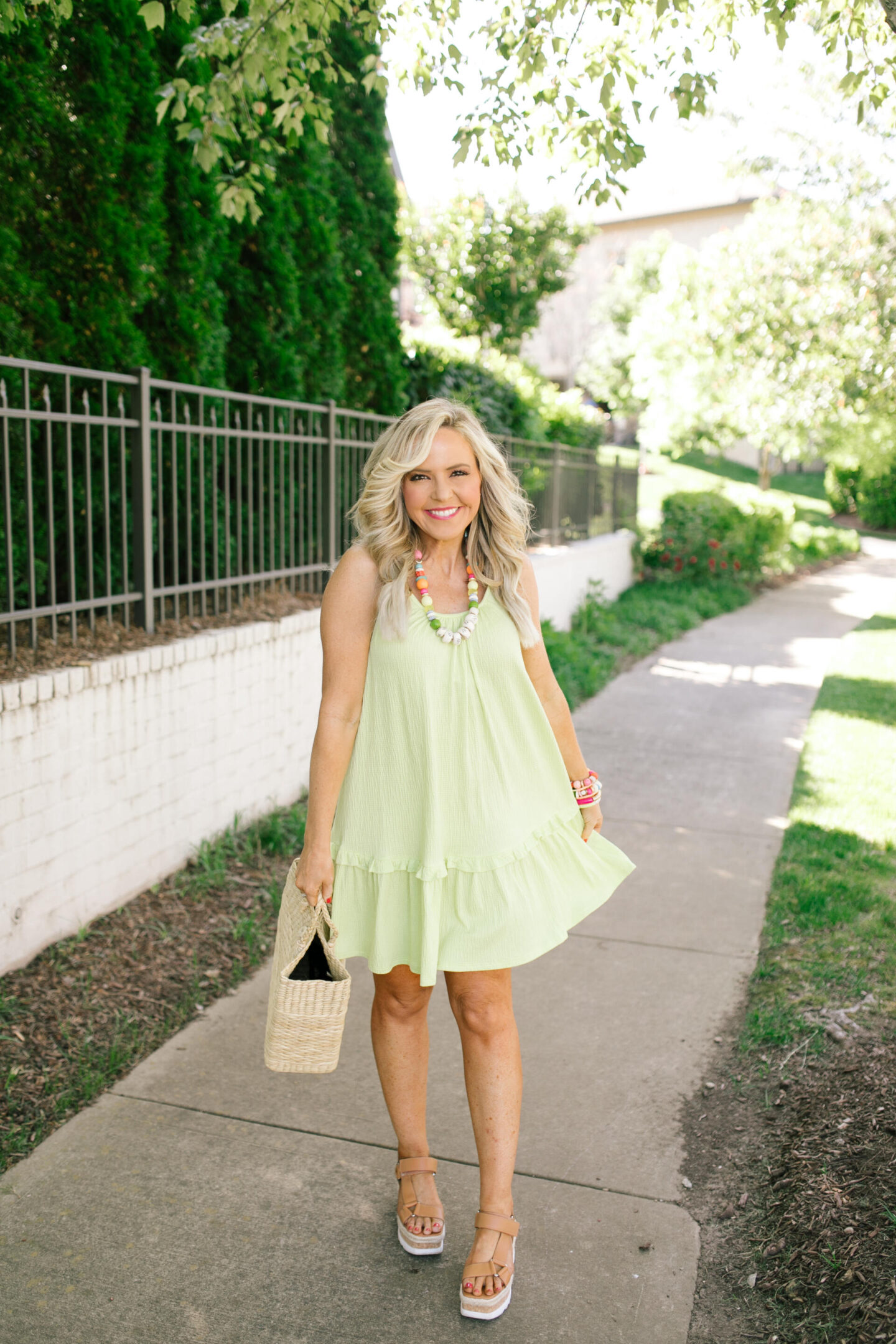 Scoop Dress by popular Nashville fashion blog, Hello Happiness: image of a woman wearing Scoop green cami rifle dress, multi color stretch bracelets, and holding a woven seagrass tote bag.