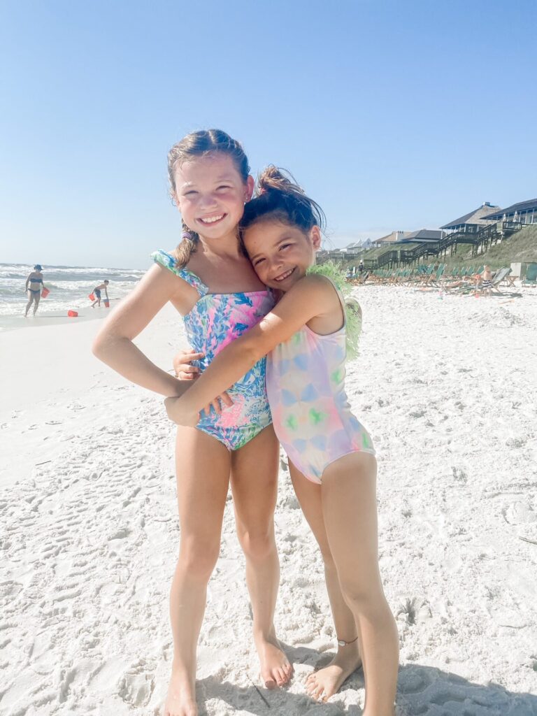 Rosemary Beach by popular Nashville travel blog, Hello Happiness: image of two young girl hugging each other at the beach. 