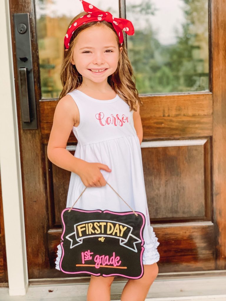 Caroline and Carson Go Back to School... And They're Off! by popular Nashville blog, Hello Happiness: image of a little girl wearing an Elegant Goods Shop dress and holding a Lovely Little Designs chalkboard sign. 