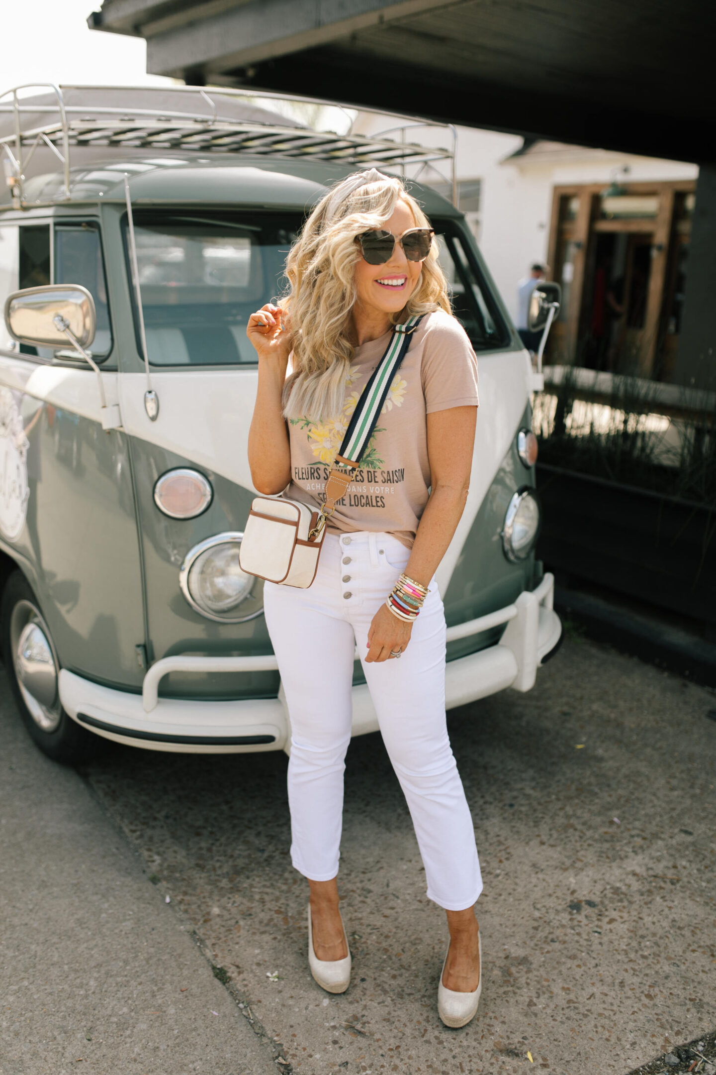 J Crew Clothing by popular Nashville fashion blog, Hello Happiness: image of a woman wearing a J Crew vintage cotton fleurs savages graphic t-shirt and white jeans. 