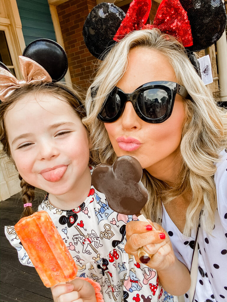 Disney Creators Celebration by popular Nashville lifestyle blog, Hello Happiness: image of a girl and her mom eating Disneyland popsicles. 