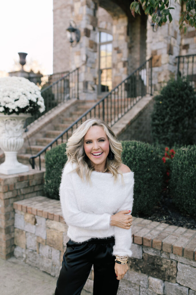 Holiday Collection by popular Nashville fashion blog, Hello Happiness: image of Natasha Stoneking wearing a feather knit off the shoulder sweater with velvet joggers and black earrings.  