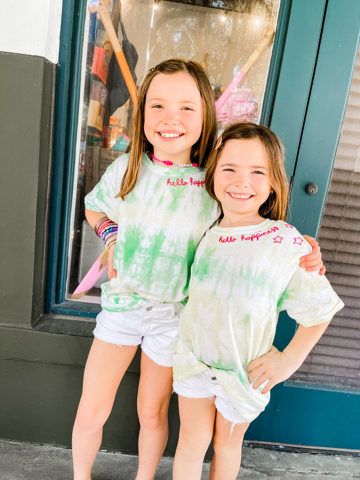 Spring Break Outfits by popular Nashville fashion blog, Hello Happiness: image of two young girls wearing a New Embroidery Custom t-shirt and Tractr brittany shorts. 