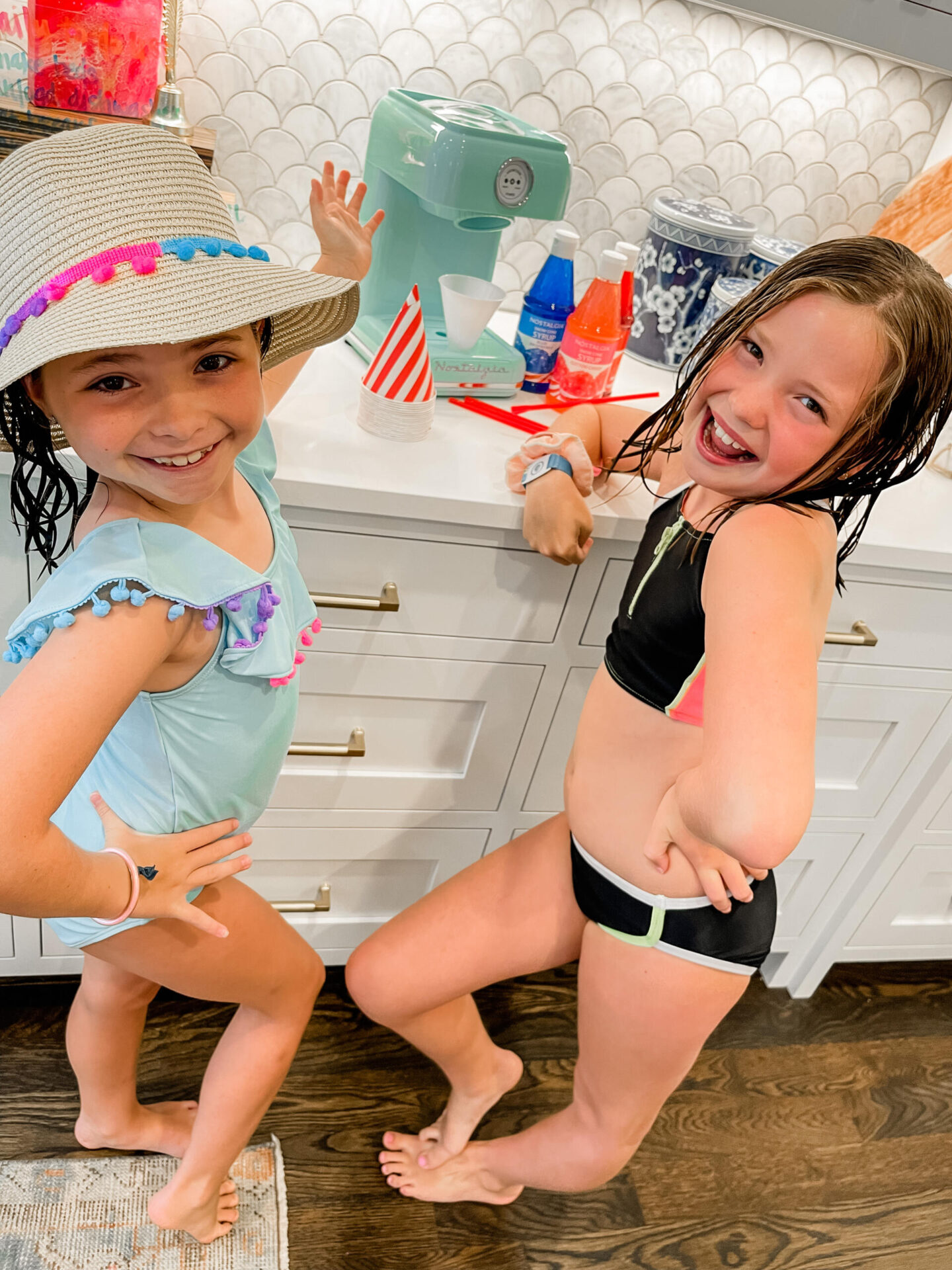 Walmart + Membership by popular Nashville lifestyle blog, Hello Happiness: image of two girls wearing swimsuits and standing next to a Nostalgia snow cone machine. 