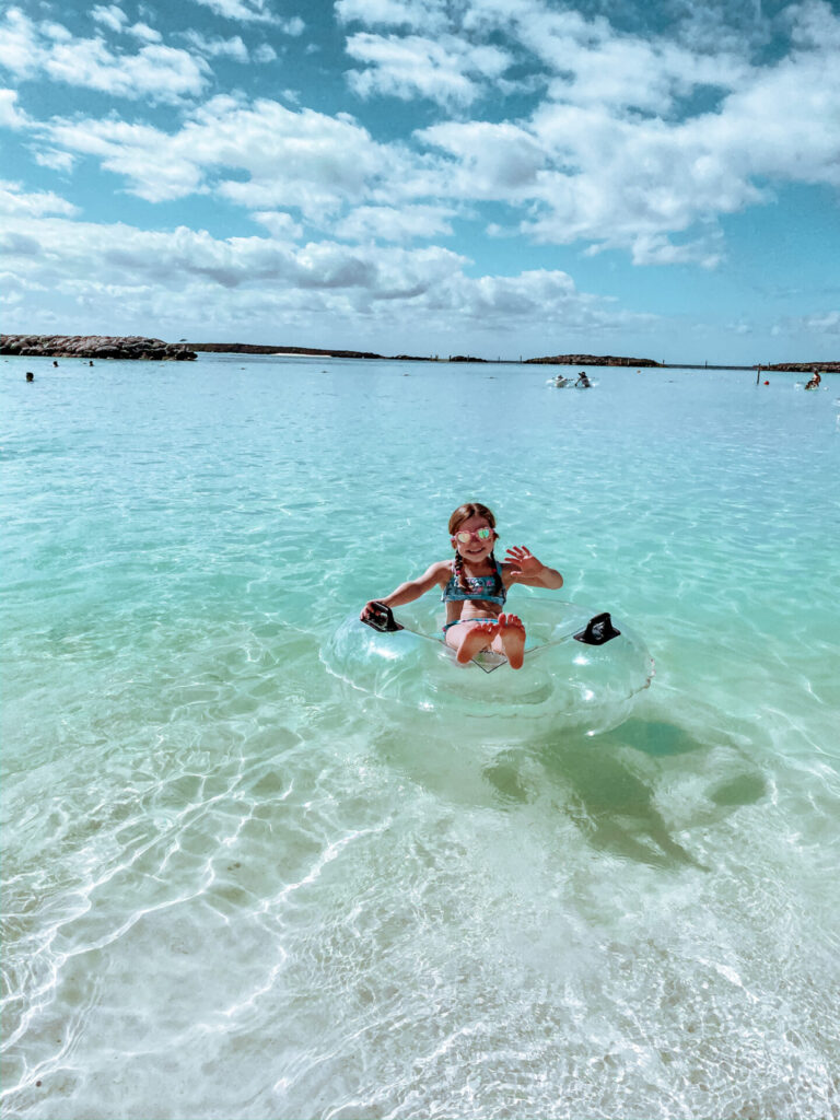 Disney Creators Celebration by popular Nashville lifestyle blog, Hello Happiness: image of a girl sitting in a inflatable tube in the ocean at Castaway Cay Bahamas. 