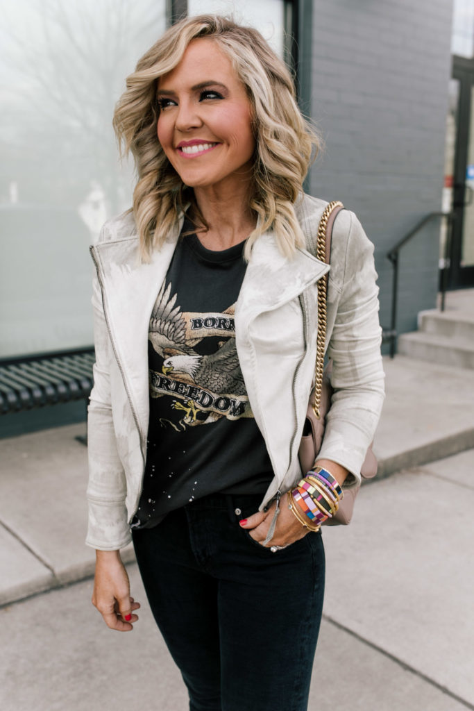 Evereve Nashville by popular Nashville fashion blog, Hello Happiness: image of a woman wearing a Evereve Marrakech Marci Moto Jacket, Evereve Chaser Born To Ride Tee, Evereve Agolde Toni Mid Rise Slim, Evereve P448 Glitter Sneaker, and enamel and beaded stack bracelets. 
