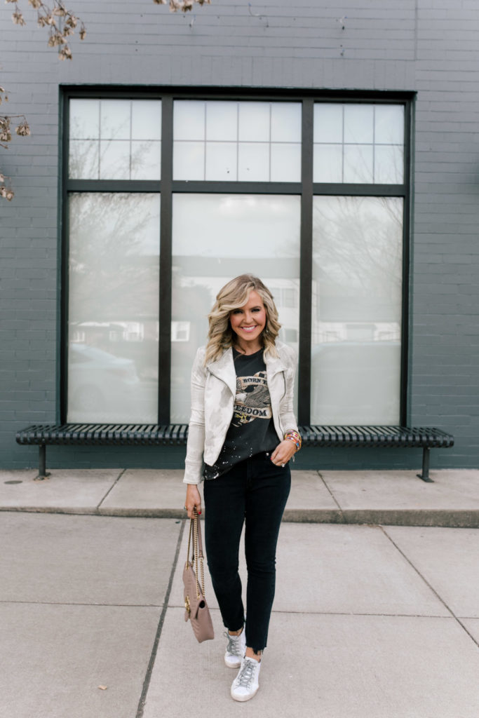 Evereve Nashville by popular Nashville fashion blog, Hello Happiness: image of a woman wearing a Evereve Marrakech Marci Moto Jacket, Evereve Chaser Born To Ride Tee, Evereve Agolde Toni Mid Rise Slim, Evereve P448 Glitter Sneaker, and enamel and beaded stack bracelets. 