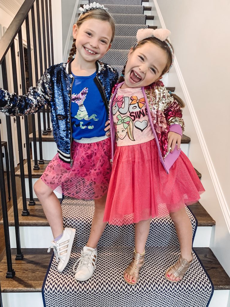 The Friday Five...by popular Nashville life and style blog, Hello Happiness: image of two girls standing on some stairs and wearing Walmart Jojo Siwa Unicorn Fashion Top and Tutu Skirt, 2-Piece Outfit Set, Jojo Siwa Foil Mesh Dress, and Target Cat & Jack Girls' Long Sleeve Striped Sequin Bomber Jacket.