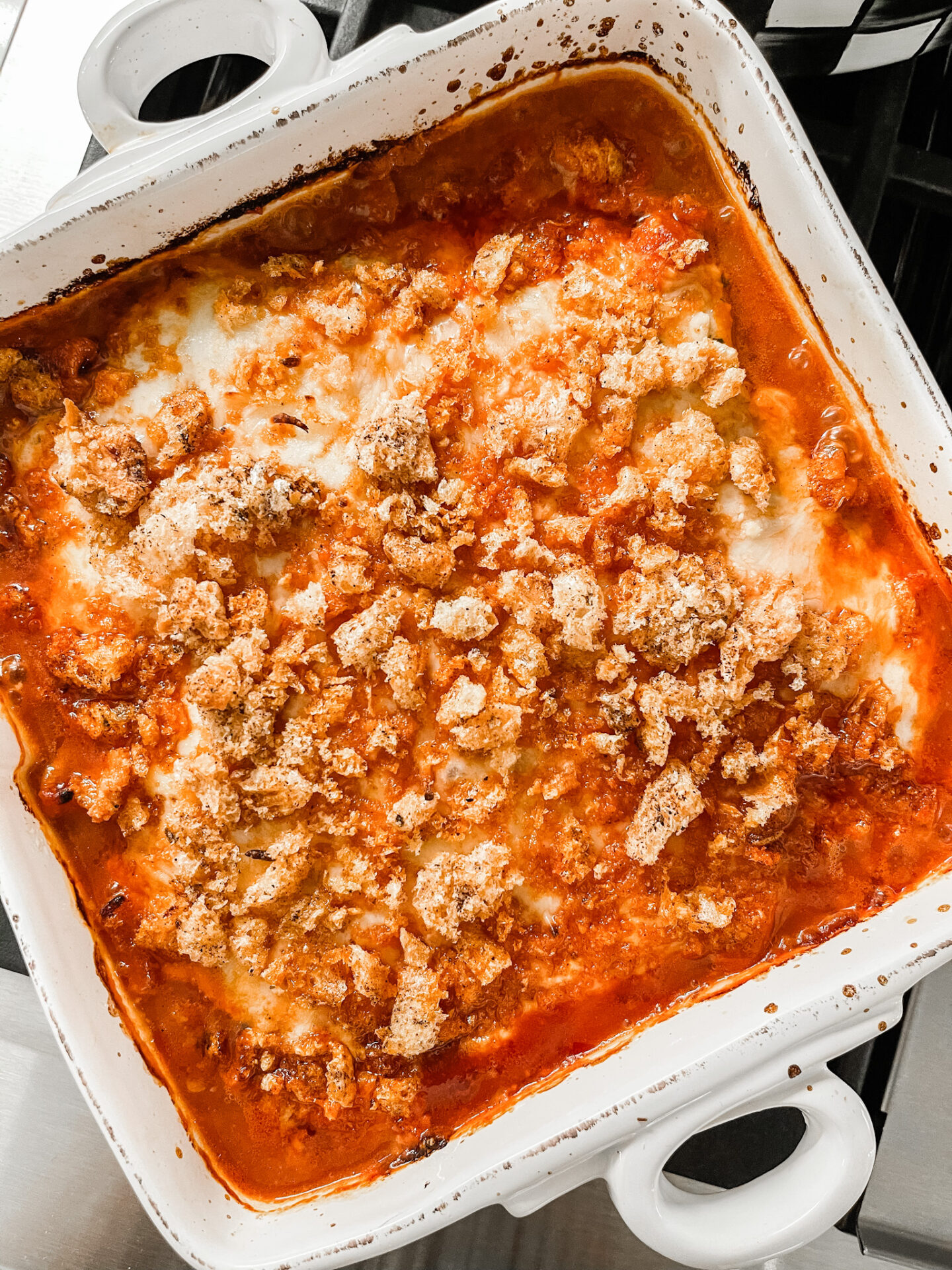 Low Carb Chicken Parmesan by popular Nashville lifestyle blog, Hello Happiness: image of low carb chicken parmesan in a white ceramic baking dish. 