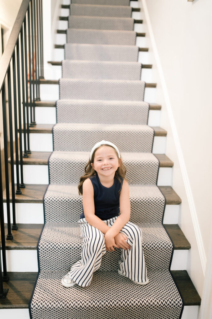 Walmart Back to School by popular Nashville life and style blog, Hello Happiness: image of a young girl sitting on a stair case and wearing a Walmart Jessica Simpson Girls Sleeveless Twist Front Top and Paper Bag Pants, Walmart Wonder Nation Shining Star Low-Top Court Sneaker.