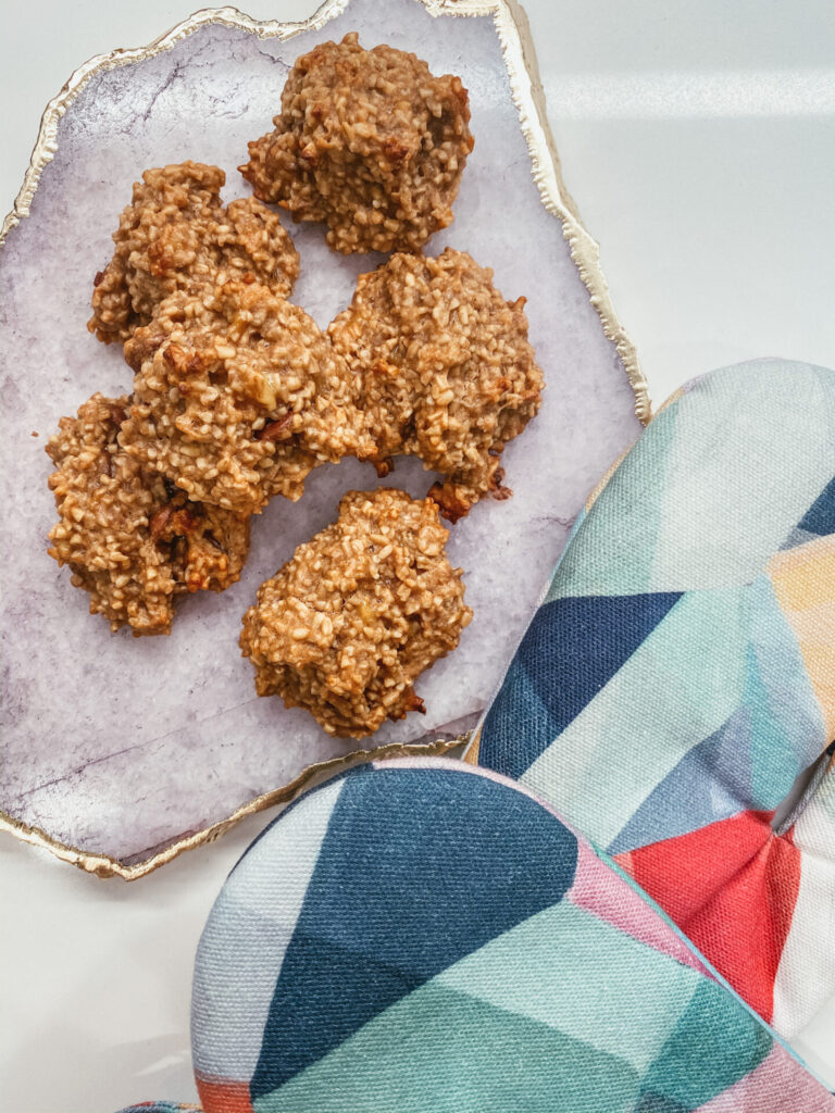 Flourless Peanut Butter Oatmeal Cookies by popular Nashville lifestyle blog, Hello Happiness: image of some flourless peanut butter banana cookies on a Anthropologie Agate Cheese Board that's next to some Minted Kaleidoscope No.1  Children’s Oven Mitts.