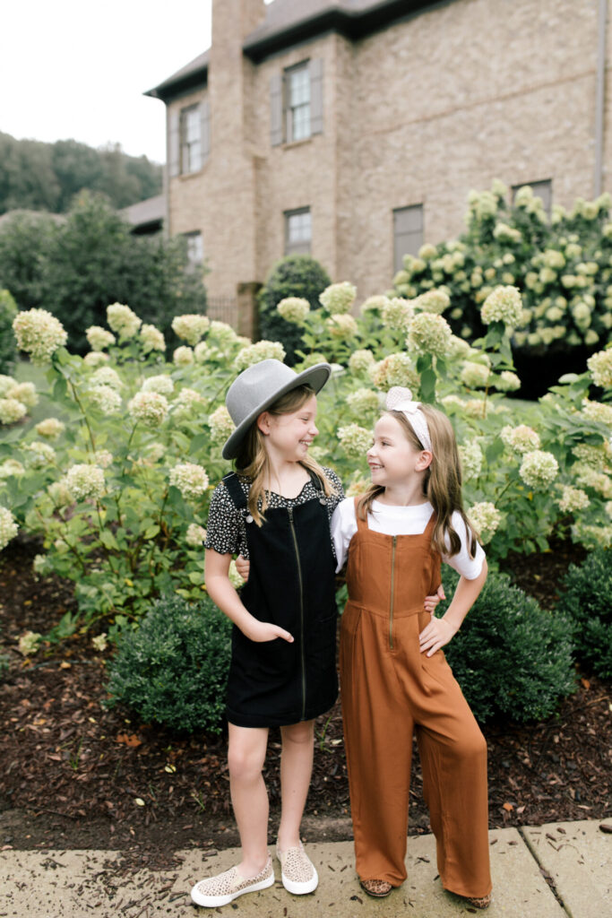 Year in Review by popular Nashville lifestyle blog, Hello Happiness: image of two young girls standing together in front of a flowering bush. 