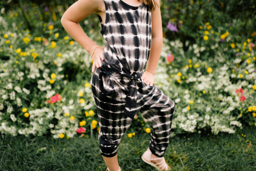 Tween Fashion by popular Nashville fashion blog, Hello Happiness: image of a girl standing outside and wearing a Target tie dye jumpsuit, gladiator sandals, and white knot headband.