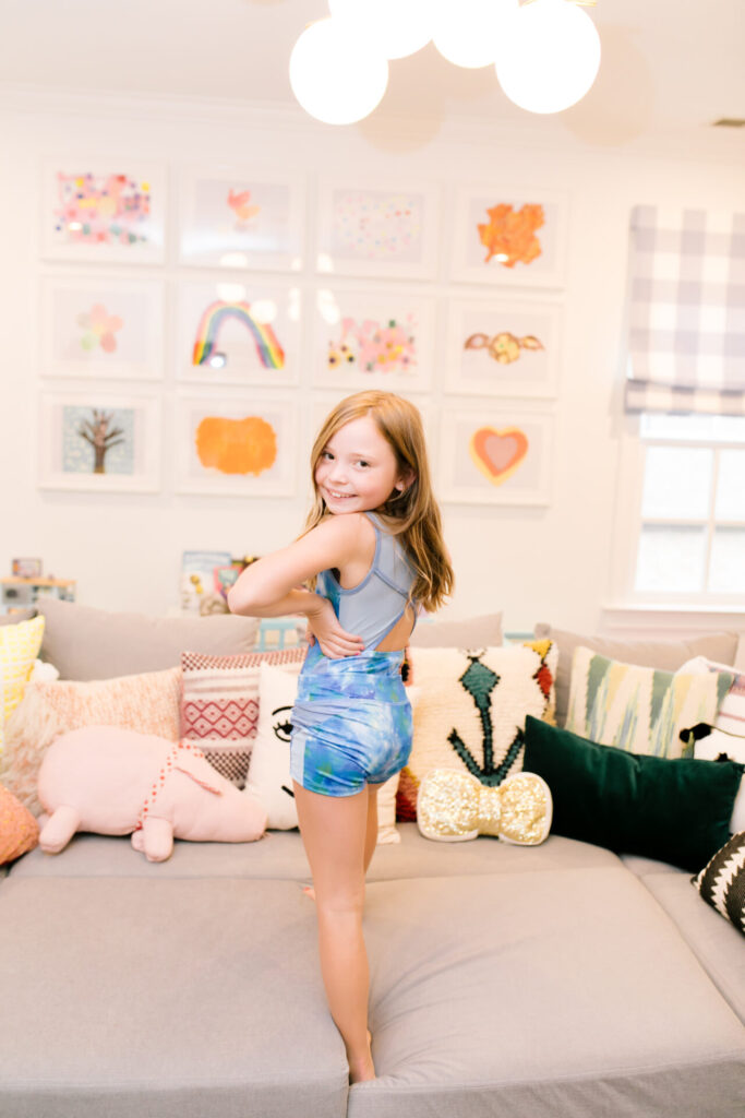 Tween Fashion by popular Nashville fashion blog, Hello Happiness: image of a girl wearing a Target blue galaxy leotard and Target gym shorts while standing on a grey couch.