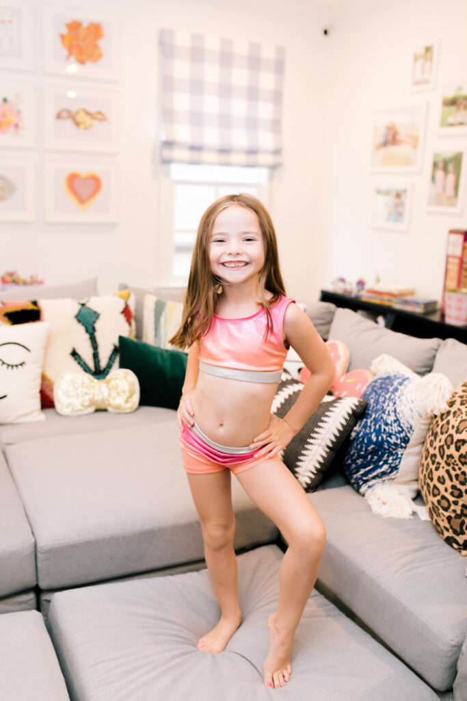 Tween Fashion by popular Nashville fashion blog, Hello Happiness: image of a girl wearing a Target sports bra and Target gym shorts while standing on a grey couch.